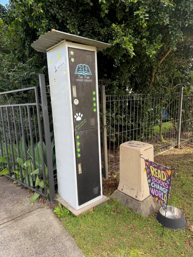 Street library using off-white colours and natural timbers combined with a slanted corrugated iron roof to create a unique design