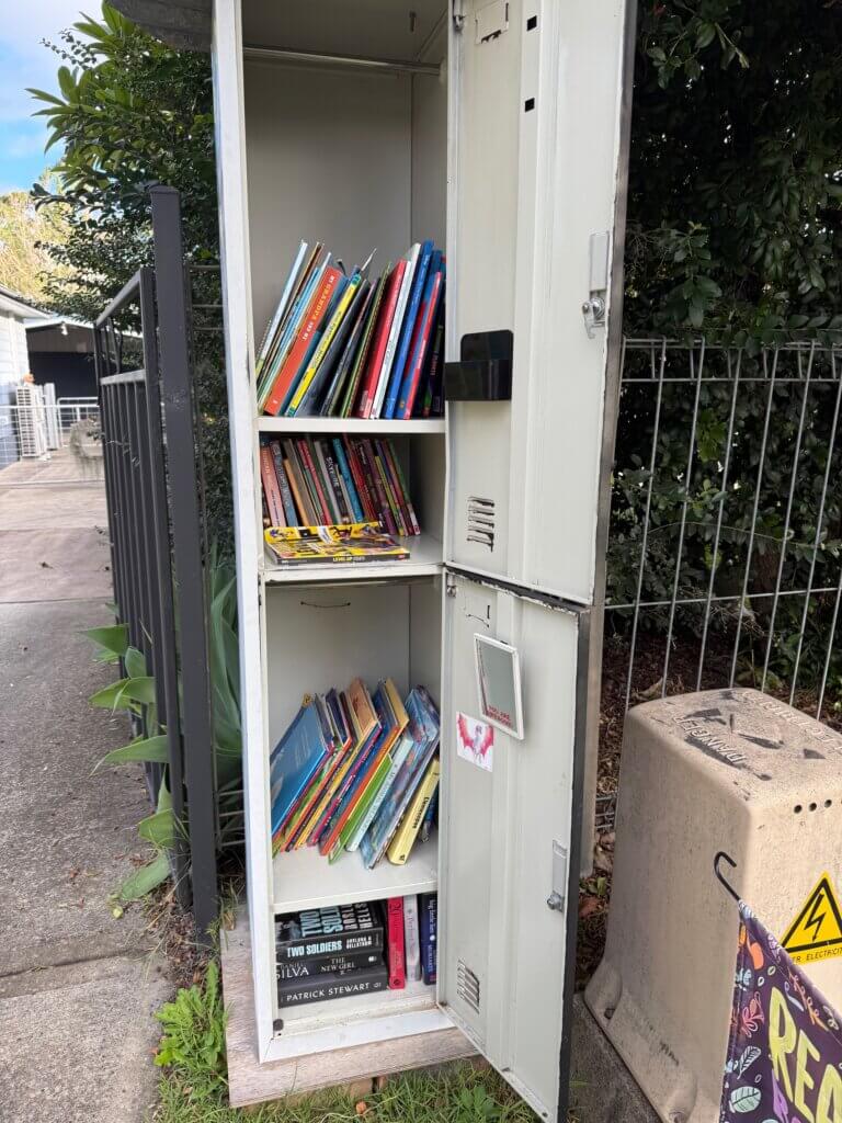 Reused locker styled as a street library, with door open showing books inside.